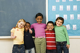 group of diverse young students standing together in classroom